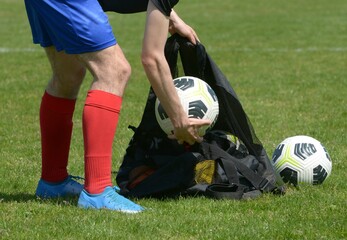 le joueur de football ramasse les ballons sur le terrain au football	