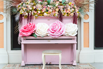 A pink piano with many colorful flowers on it.