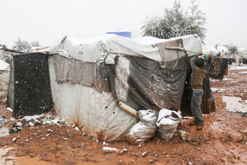 refugee child playing in the snow that fell on the camp