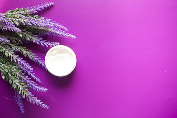 Obraz na płótnie Canvas beauty cream and lavender flower on purple background 