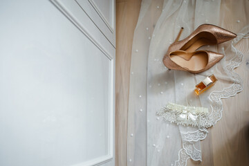 wedding gold shoes, perfume and wedding garter on the veil