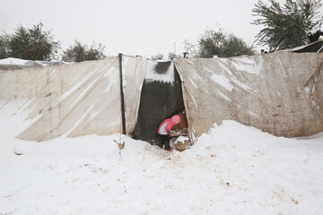 refugee child playing in the snow that fell on the camp