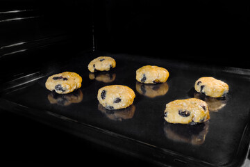 Six uncooked homemade oatmeal cookies in row on metal sheet in oven. Dessert, cookery, baking, gastronomy, food concept