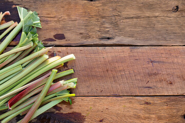 Organic vegetarian food. Fresh rhubarb cuttings on a wooden table.