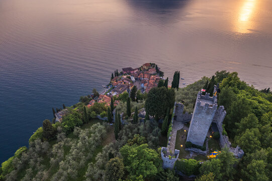 Aerial view of Vezio Castle and Varenna village in background during summer sunset. Drone shot in Como lake. Varenna, Italy