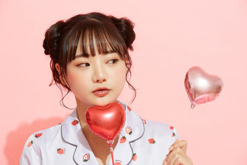 パジャマを着た若い女性のピンク背景のかわいいポートレート
