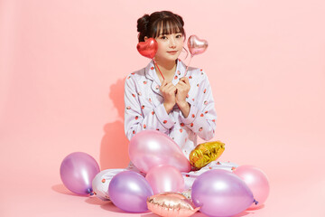 パジャマを着た若い女性のピンク背景のかわいいポートレート