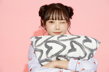 パジャマを着た若い女性のピンク背景のかわいいポートレート