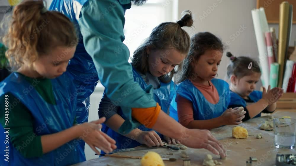 Sticker Group of little kids with teacher working with pottery clay during creative art and craft class at school.