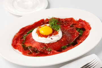 white dish with carpaccio of beef