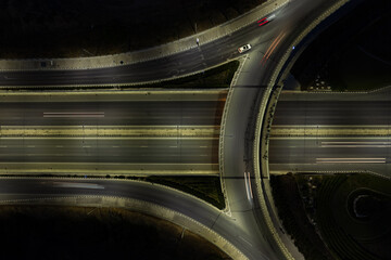 Aerial drone top view of motorway highway junction. roundabout with cars moving fast....