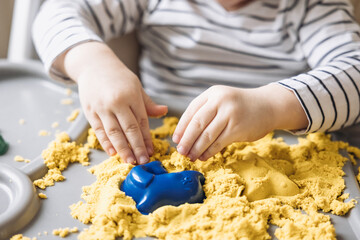 Cute little boy playing with kinetic sand. Development of fine motor skills. Early sensory education. Activities Montessori. Sensory plays at home.