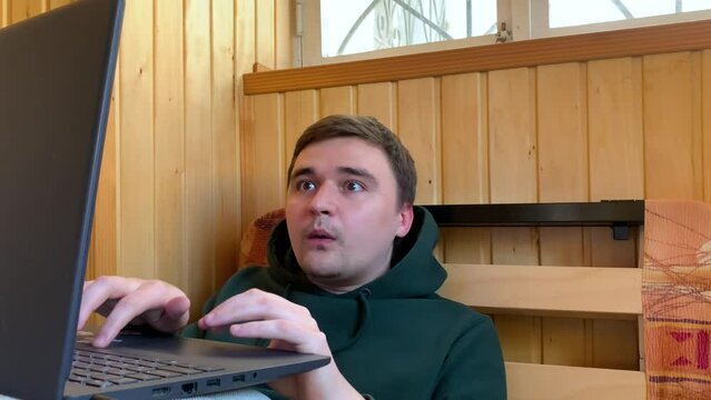 Man showing different emotions while playing video games on his gaming laptop 