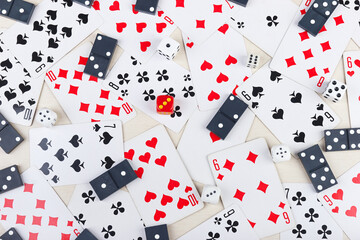 Dominoes, playing cards and dice for board games on light table. View from above.