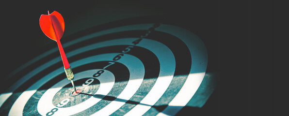 Bullseye target goal or dartboard has dart arrow throw hitting center shooting for financial...