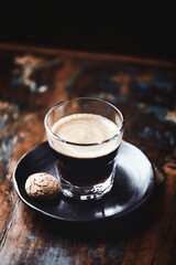 Coffee in glass cup on dark wooden background. Close up.