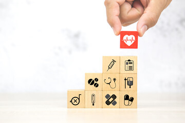 Hand choose heartbeat pulse signal or heart rhythm icon on cube wooden block stack with health care...