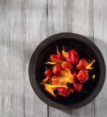 Flaming habanero chilies on cast iron plate