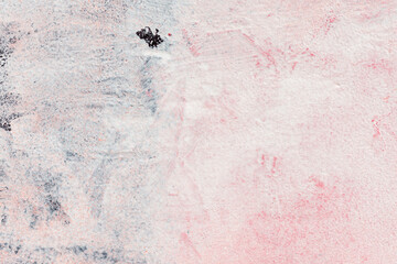 Surface texture of a painted wall with white paint with black and pink spots