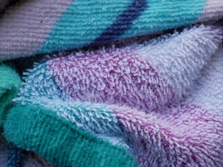colored terry cloth towel, rolled and irregular - obrazy, fototapety, plakaty