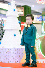 Merry Christmas boy  dress up green suit for Christmas celebrations.