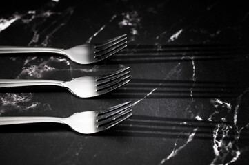 Silver forks on black marble background. Mockup