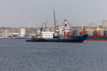 View of an oil tanker, ready to dock at the Port of Luanda, port logistics center with containers,...