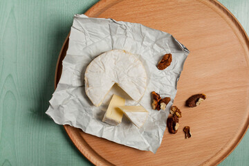 cheese brie camembert and walnuts, on a wooden light background. view from above. Camembert cheese....