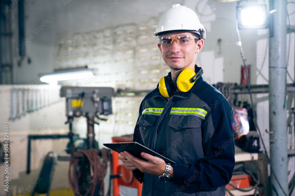 Poster young factory worker using adept tablet computer in a workshop building . industrial technology and 