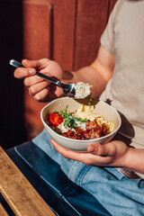 breakfast porridge with tomatoes, healthy food, the guy is holding a plate