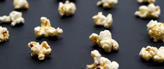 Popcorn on an black background, close-up, long banner