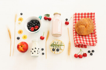 top view photo of dairy products over white wooden background. Symbols of jewish holiday - Shavuot