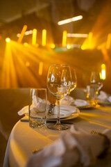 Empty glass set in restaurant. wedding, decor, celebration, holiday concept - romantic table setting with white tablecloth, plates, crystal glasses