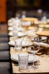 Empty glass set in restaurant. wedding, decor, celebration, holiday concept - romantic table setting with white tablecloth, plates, crystal glasses