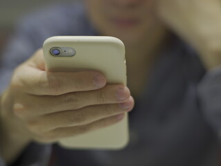 Hand holding smartphone, background blur