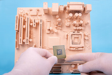 motherboard and a hand holding a microprocessor on a blue background in paint