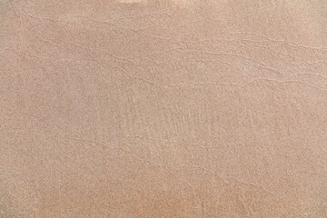 Wet sand texture background. Sandy beach close up top view, copy space. Summer vacation template