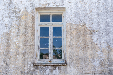 Fototapeta na wymiar Window with blue open shutter on white wall. Cyclades island house, Greek traditional architecture.