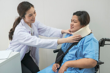Fototapeta premium Young Doctors checking Patient after treatment. Young Female Doctor checking on patient after neck pain. Doctor writing a prescription to her patient. Female doctor talk consult patient.