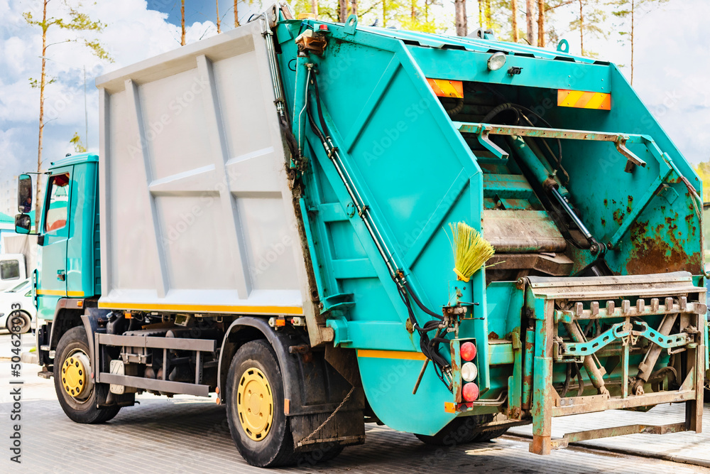 Poster A garbage truck picks up garbage in a residential area. Loading mussar in containers into the car. Separate collection and disposal of garbage. Garbage collection vehicle.