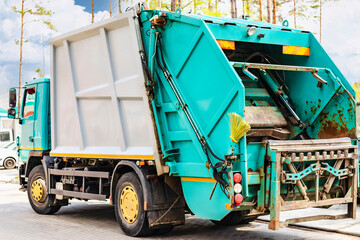 A garbage truck picks up garbage in a residential area. Loading mussar in containers into the car....