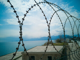 Fight for freedom symbol. Loops of spiked or razor wire curling around long stretches of barbed...