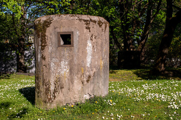 Air duct of a bomb shelter in the center of Kaliningrad. Military buildings in a sunny flower meadow