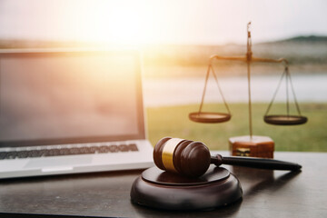 Justice and law concept.Male judge in a courtroom with the gavel, working with, computer and...