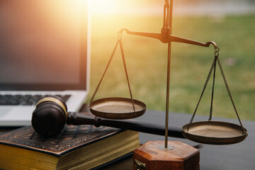 Justice and law concept.Male judge in a courtroom with the gavel, working with, computer and docking keyboard, eyeglasses, on table in morning light