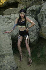 beautiful fashionable adult tattoo girl warrior amazon on the stones of the desert greek woman ukrainian in the war