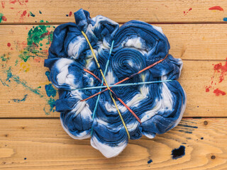 A blank for a tie dye shirt on a wooden table. Flat lay.