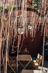 glass lampshades, tree branches decorated with pink ribbons. design of a summer cafe on the street of Ukraine