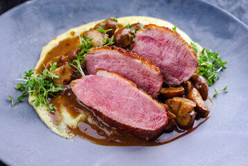 Gegrilltes Gourmet Entenbrust Filet mit Polenta und karamellisierten Champignons in herzhafter Bier...