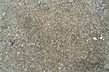 Earth floor texture with sand and pebbles. Top view. Closeup